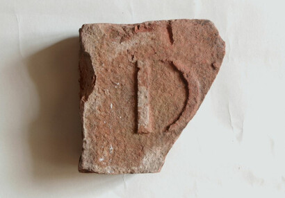 Bruchstück eines Ziegelsteins mit der Markierung einer bisher unbekannten Werkstatt, Fund aus dem nordöstlichen Teil des Burgkerns.