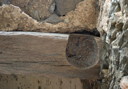 Wooden lintel with a hole for attaching the gate.