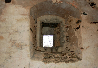 Graduated window reveals in the second floor of the north wing with surrounding graffiti.
